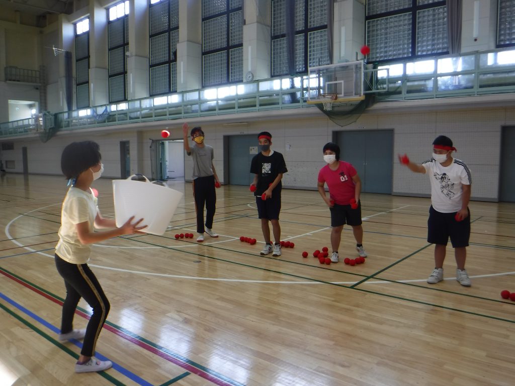 秋の運動会　かごにボールを入れよう　白チームの選手が、かごを持っているので、なかなか入らない。